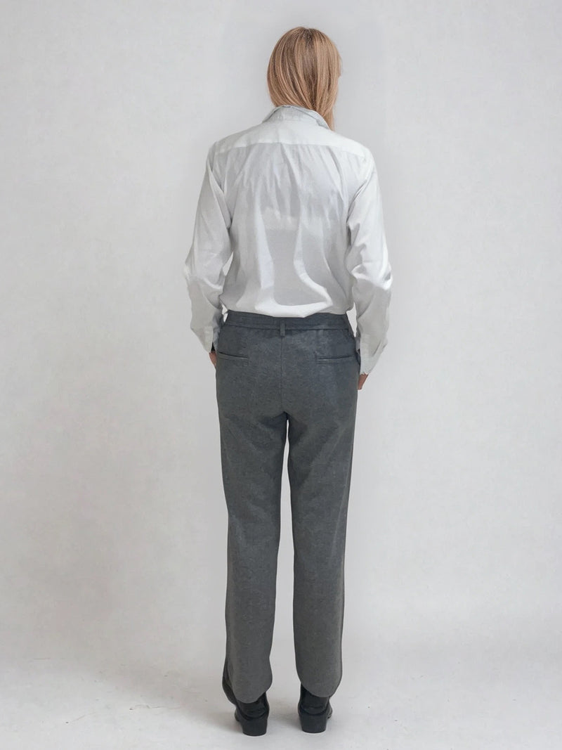 Pantalon droit gris avec un motif chevrons fines rayures. La taille dans le dos est élastiquée. Poches italiennes, patte au niveau d'un passant rehaussée d'un fil lurex. Vue dos.