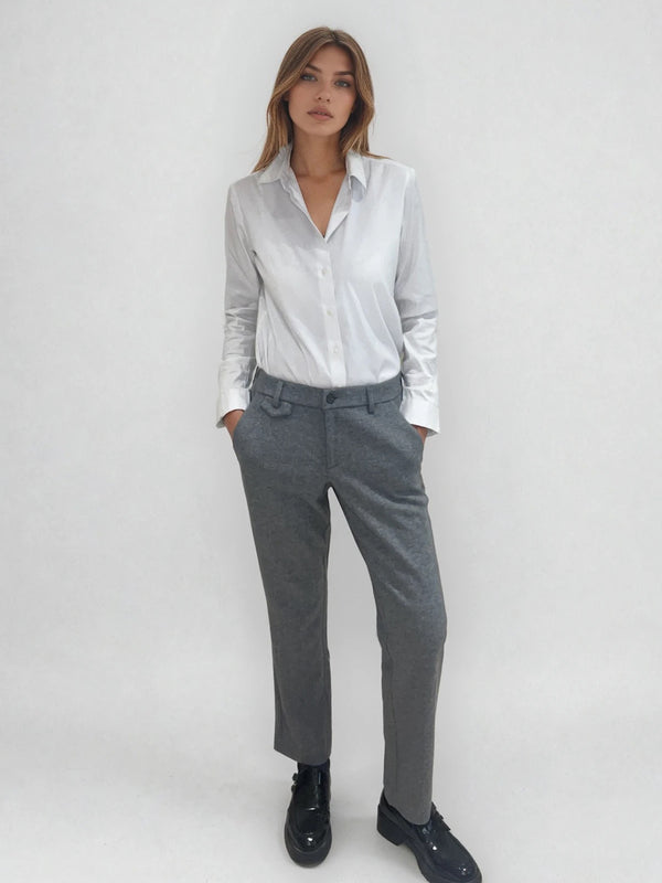 Pantalon droit gris avec un motif chevrons fines rayures. La taille dans le dos est élastiquée. Poches italiennes, patte au niveau d'un passant rehaussée d'un fil lurex. Vue face.