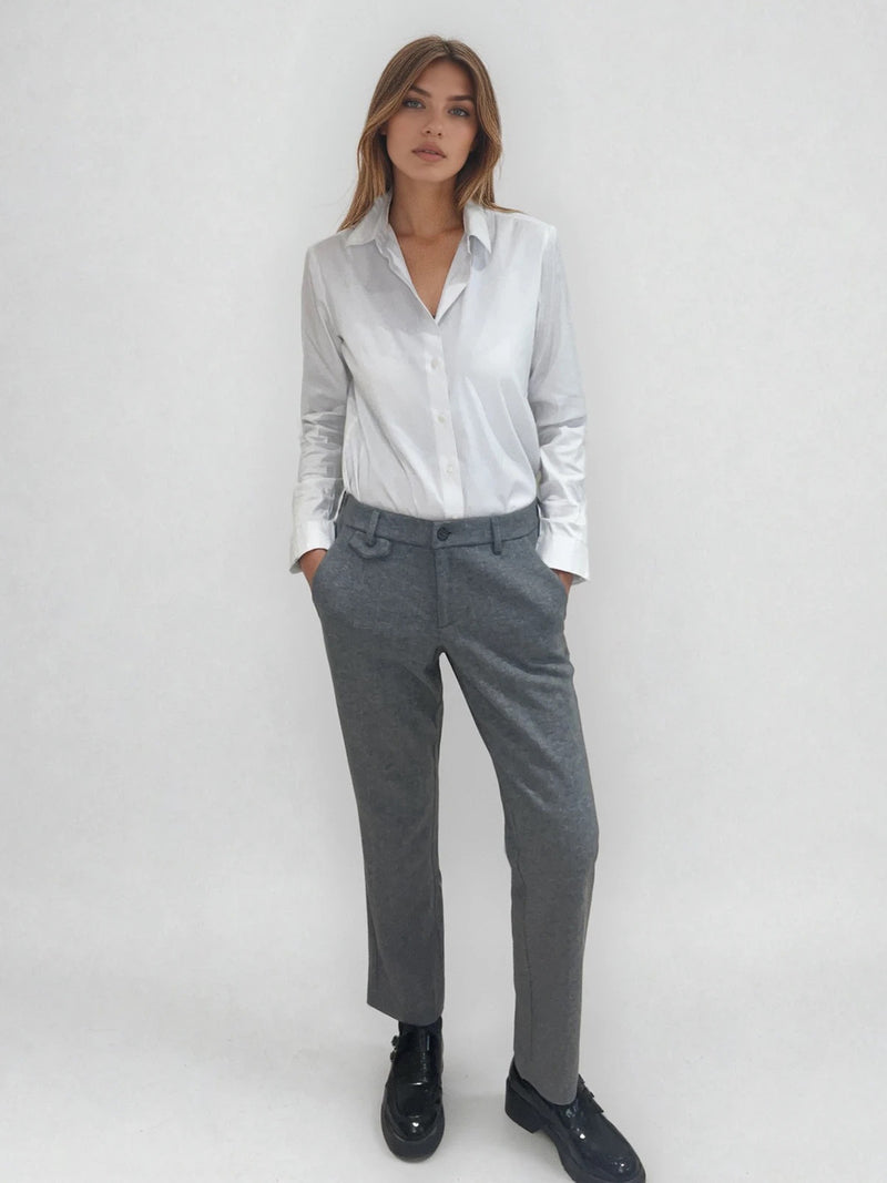 Pantalon droit gris avec un motif chevrons fines rayures. La taille dans le dos est élastiquée. Poches italiennes, patte au niveau d'un passant rehaussée d'un fil lurex. Vue face.