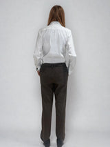 Pantalon droit marron chocolat avec un motif chevrons fines rayures. La taille dans le dos est élastiquée. Poches italiennes, patte au niveau d'un passant rehaussée d'un fil lurex. Vue dos.