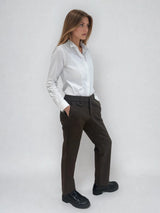 Pantalon droit marron chocolat avec un motif chevrons fines rayures. La taille dans le dos est élastiquée. Poches italiennes, patte au niveau d'un passant  rehaussée d'un fil lurex. Vue profil.