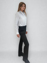 Pantalon de forme bootcut souple et confortable: jambe légèrement appuyée et bas évasé. Le tissu marron est imprimé de petits croisillons beige et vert. La ceinture de ce leggings est recouverte du même tissu, les œillets sont dorés ainsi que le bouton. Esprit années 70's. Le tissu est composé de 69% polyester, 27% rayon, 4% élasthanne. Vue profil.