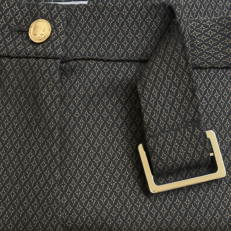 Pantalon de forme bootcut souple et confortable: jambe légèrement appuyée et bas évasé. Le tissu marron est imprimé de petits croisillons beige et vert. La ceinture de ce leggings est recouverte du même tissu, les œillets sont dorés ainsi que le bouton. Esprit années 70's. Le tissu est composé de 69% polyester, 27% rayon, 4% élasthanne. Vue détail de la ceinture.