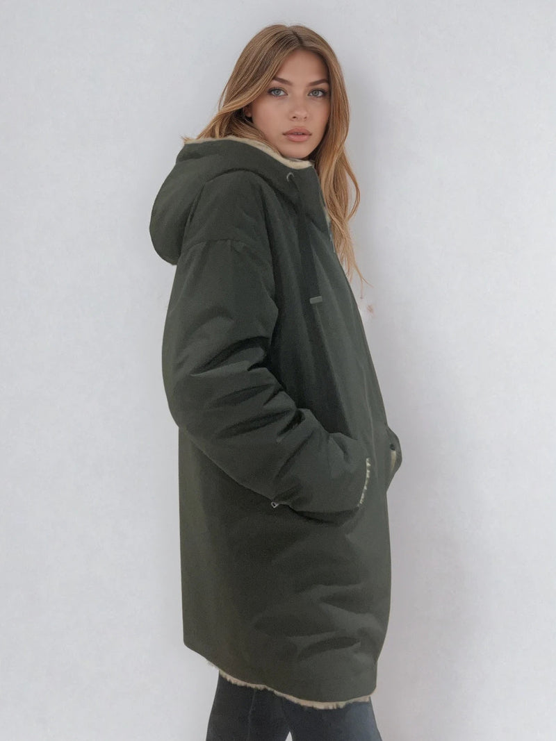 Parka kaki avec capuche doublée en 100% polyester réversible avec d'un côté une face déperlante marine et de l'autre une face façon fausse fourrure beige. Elle se ferme par un zip, a 2 poches zippées côté déperlant . Le bas des manches se retournent,  elle a une coupe droite et arrive à mi-cuisses. Vue profil.