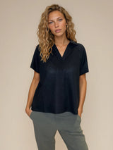 Polo femme manches courtes coloris noir. Le polo est en 100% polyester, il a une maille texturée en nid d'abeille. Petit col sur une ouverture V. Forme droite, maille légère et aérienne.
Vue face.