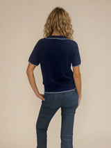 Polo coloris marine pour femme avec manches courtes, esprit tennis. L' encolure V est rehaussée par une rayure grise, détail présent également sur le bas des manches. Petit col.
100%viscose.
Vue dos.