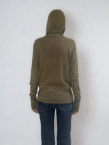 Pull encolure ronde souple avec capuche coloris kaki en 100% laine mérinos. Manches longues terminées par un long poignet côtelé avec une ouverture pour y glisser le pouce comme une mitaine. Emmanchures raglan, large bande côtelée sur le bas. Vue dos.