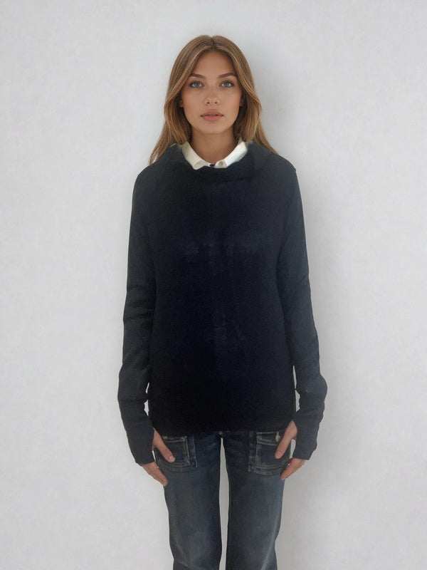 Pull encolure ronde  souple avec capuche coloris marine en 100% laine mérinos. Manches longues terminées par un long poignet côtelé avec une ouverture pour y glisser le pouce comme une mitaine. Emmanchures raglan, large bande côtelée sur le bas. Vue face.