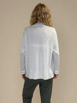 Pull manches longues col rond. Le pull est beige, a un col blanc très arrondi rehaussé d'une bande bleu ciel, détail présent aussi sur le bas des manches. Coupe souple avec une asymétrie sur les côtés.
Composition: 83%viscose et 17% nylon. Vue dos.