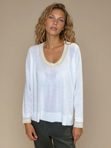 Pull manches longues col rond. Le pull est blanc, a un col beige très arrondi rehaussé d'une bande jaune pale, détail présent aussi sur le bas des manches. Coupe souple avec une asymétrie sur les côtés.
Composition: 83%viscose et 17% nylon. Vue face.