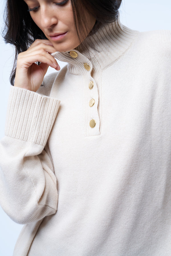 Pull camionneur beige pour femme. La coupe est oversize, le col est féminisé par 4 boutons dorés brossés, il peut s'ouvrir. Les emmanchures sont basses pour apporter plus d'ampleur. Il est fendu sur les côtés et asymétrique. Finitions larges côtes sur les manches et le bas. Détail du col boutonnés.
Composition: 42%cachemire, 8% soie, 50%mérinos.











l