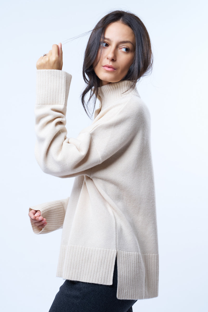 Pull camionneur beige pour femme. La coupe est oversize, le col est féminisé par 4 boutons dorés brossés, il peut s'ouvrir. Les emmanchures sont basses pour apporter plus d'ampleur. Il est fendu sur les côtés et asymétrique. Finitions larges côtes sur les manches et le bas. Vue profil de l'asymétrie.
Composition: 42%cachemire, 8% soie, 50%mérinos.











