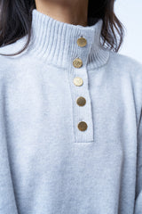 Pull camionneur gris clair pour femme. La coupe est oversize, le col est féminisé par 4 boutons dorés brossés, il peut s'ouvrir. Les emmanchures sont basses pour apporter plus d'ampleur. Il est fendu sur les côtés et asymétrique. Finitions larges côtes sur les manches et le bas. Détail du col avec les boutons dorés.
Composition: 42%cachemire, 8% soie, 50%mérinos.











