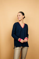 Pull EMILIA fond marine avec col V et bas de manches longues bicolores: bandes camel et fushia. Fentes côtés asymétriques. Composition: 50%mohair, 36%nylon, 14%laine.
