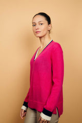 Pull EMILIA fond rose fushia avec col V et bas de manches longues bicolores: bandes marine et écru. Fentes côtés asymétriques. Composition: 50%mohair, 36%nylon, 14%laine.
