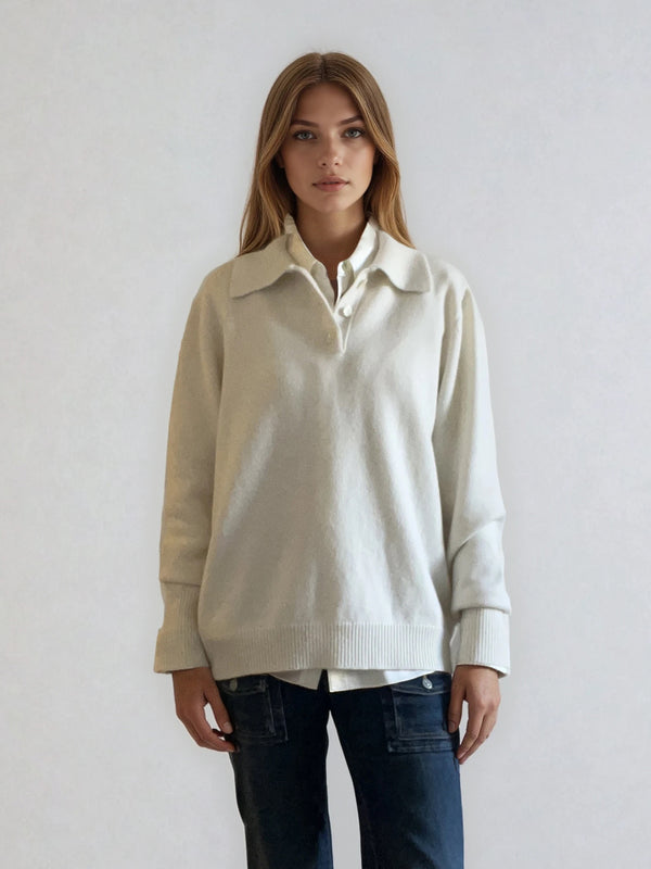 Pull polo écru en 42% cachemire, 8% soie, 50% mérinos. Le polo a un col large et ouvert avec 3 boutons. La coupe est droite et confort. Finitions côtes. Vue face.