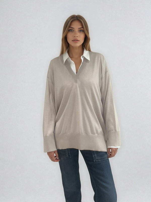 Pull manches longues col V coloris beige en 100% mérinos extra fine. L'encolure est bordée d'une bande côtelée. Les manches se terminent par de larges côtes qui permettent de porter un chemisier avec facilité. Finitions larges côtes  également sur le bas. Le pull est fendu sur les côtés sur 10 cm.
Vue face.