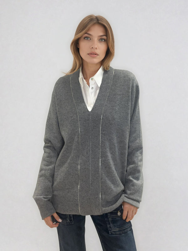 Pull manches longues coloris gris en 100% cachemire avec un col V.  Une bande de dents de fermeture éclair commence en bas et vient entourer  tout le tour de l'encolure. Coupe droite, le pull est confort et long. Finitions côtes. Vue face.