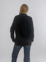 Pull manches longues coloris noir en 100% cachemire avec un col V.  Une bande de dents de fermeture éclair commence en bas et vient entourer  tout le tour de l'encolure. Coupe droite, le pull est confort et long.  Finitions côtes. Vue dos.