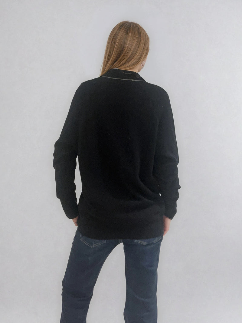 Pull manches longues coloris noir en 100% cachemire avec un col V.  Une bande de dents de fermeture éclair commence en bas et vient entourer  tout le tour de l'encolure. Coupe droite, le pull est confort et long.  Finitions côtes. Vue dos.