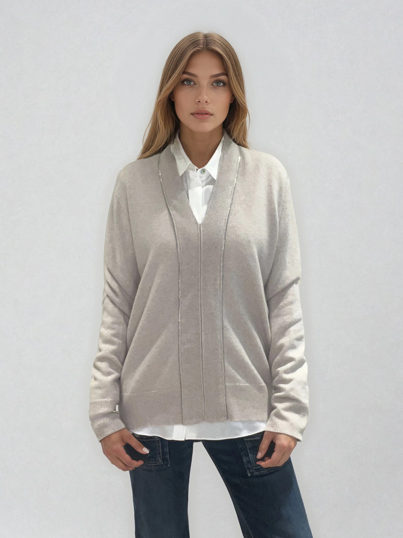 Pull manches longues coloris taupe en 100% cachemire avec un col V .  Une bande de dents de fermeture éclair commence en bas et vient entourer  tout le tour de l'encolure. Finitions côtes. Coupe droite, le pull est confort et long. Vue face.