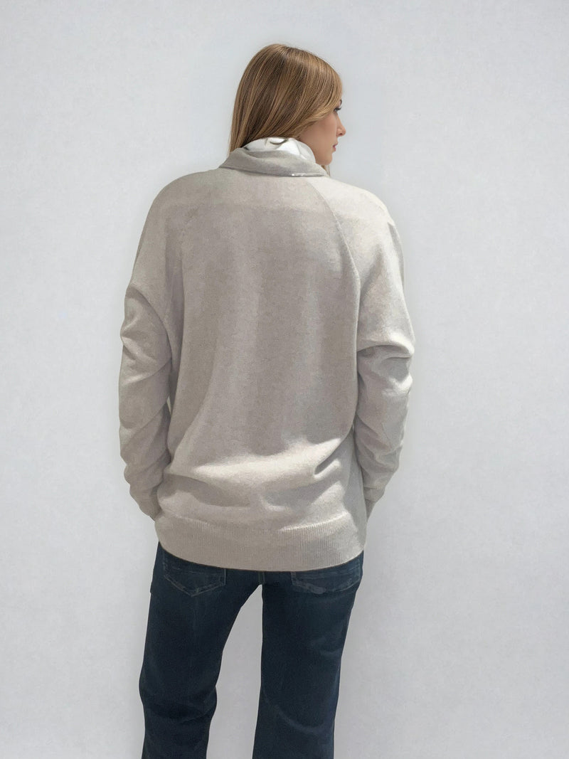 Pull manches longues coloris taupe en 100% cachemire avec un col V .  Une bande de dents de fermeture éclair commence en bas et vient entourer  tout le tour de l'encolure. Finitions côtes. Coupe droite, le pull est confort et long. Vue dos.