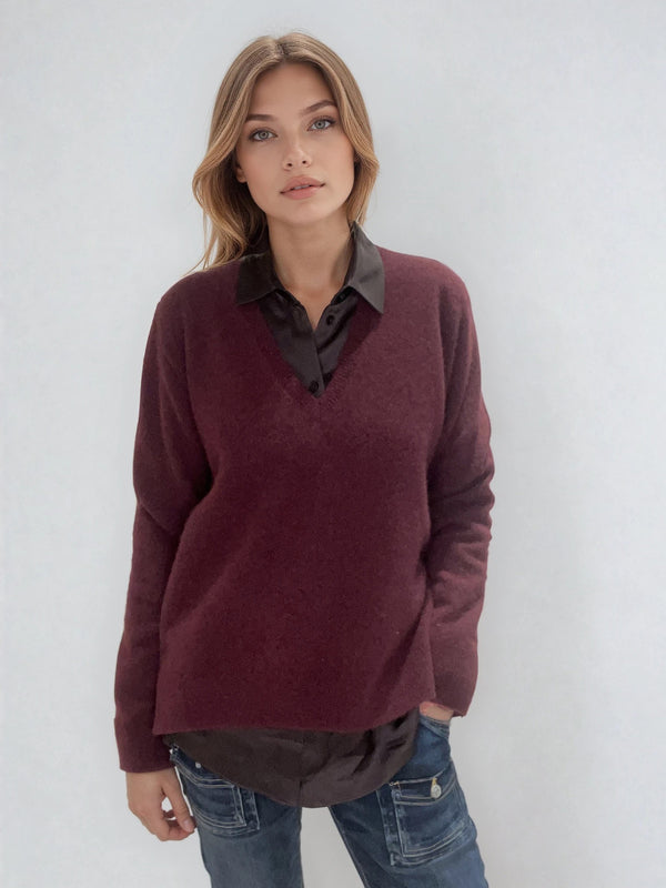 Pull manches longues coloris bordeaux avec un col V et une forme droite. Fentes asymétriques sur les côtés. Le pull est particulièrement doux, il associe du cachemire et de la soie. Finitions côtes. Vue face.