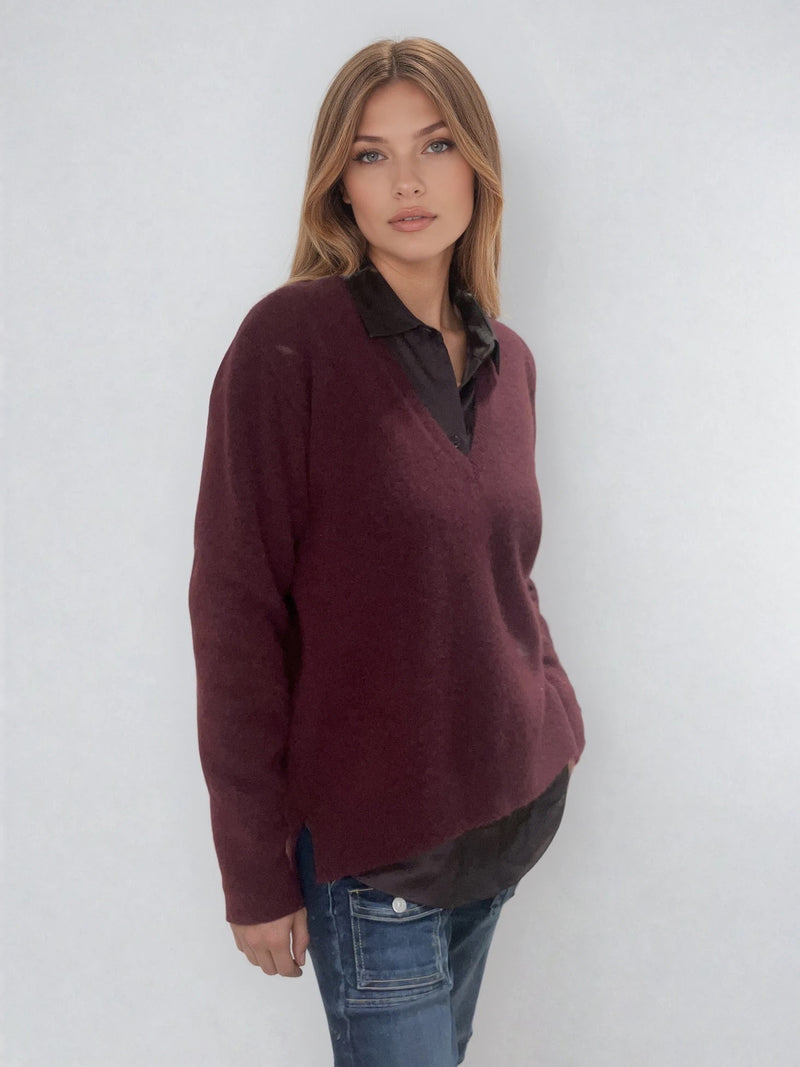 Pull manches longues coloris bordeaux avec un col V et une forme droite. Fentes asymétriques sur les côtés. Le pull est particulièrement doux, il associe du cachemire et de la soie. Finitions côtes. Vue profil.