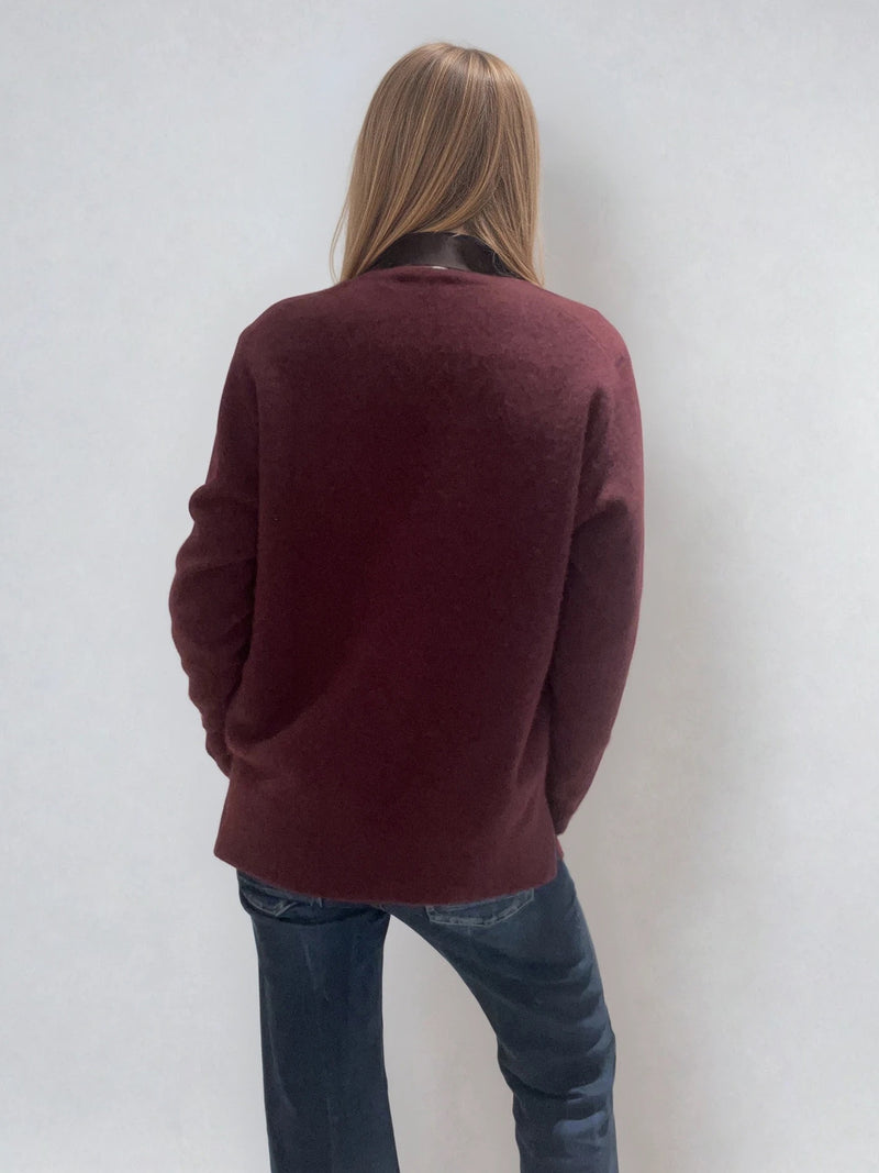 Pull manches longues coloris bordeaux avec un col V et une forme droite. Fentes asymétriques sur les côtés. Le pull est particulièrement doux, il associe du cachemire et de la soie. Finitions côtes. Vue dos.