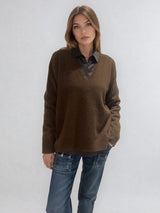 Pull manches longues coloris chocolat avec un col V et une forme droite. Fentes asymétriques sur les côtés. Le pull est particulièrement doux, il associe du cachemire et de la soie. Finitions côtes. Vue face.