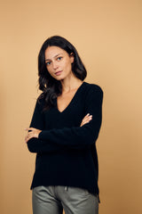 Pull manches longues coloris noir avec une forme droite. Fentes asymétriques sur les côtés. Le pull est particulièrement doux, il associe du cachemire et de la soie. Finitions côtes. Vue face.