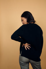 Pull manches longues coloris noir avec un col V et une forme droite. Fentes asymétriques sur les côtés. Le pull est particulièrement doux, il associe du cachemire et de la soie. Finitions côtes. Vue dos.