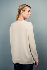 Pull manches longues coloris beige 100% cachemire, fendu sur les côtés avec asymétrie: 10 cm dans le dos et 7 cm devant. Finitions bords côtes. 