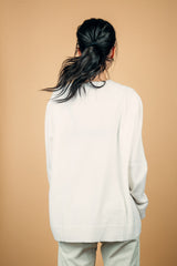 Pull manches longues coloris blanc 100% cachemire, fendu sur les côtés avec asymétrie: 10 cm dans le dos et 7 cm devant. Finitions bords côtes. 