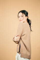 Pull manches longues coloris camel  100% cachemire, col V profond, fendu sur les côtés avec asymétrie: 10 cm dans le dos et 7 cm devant. Finitions bords côtes. 