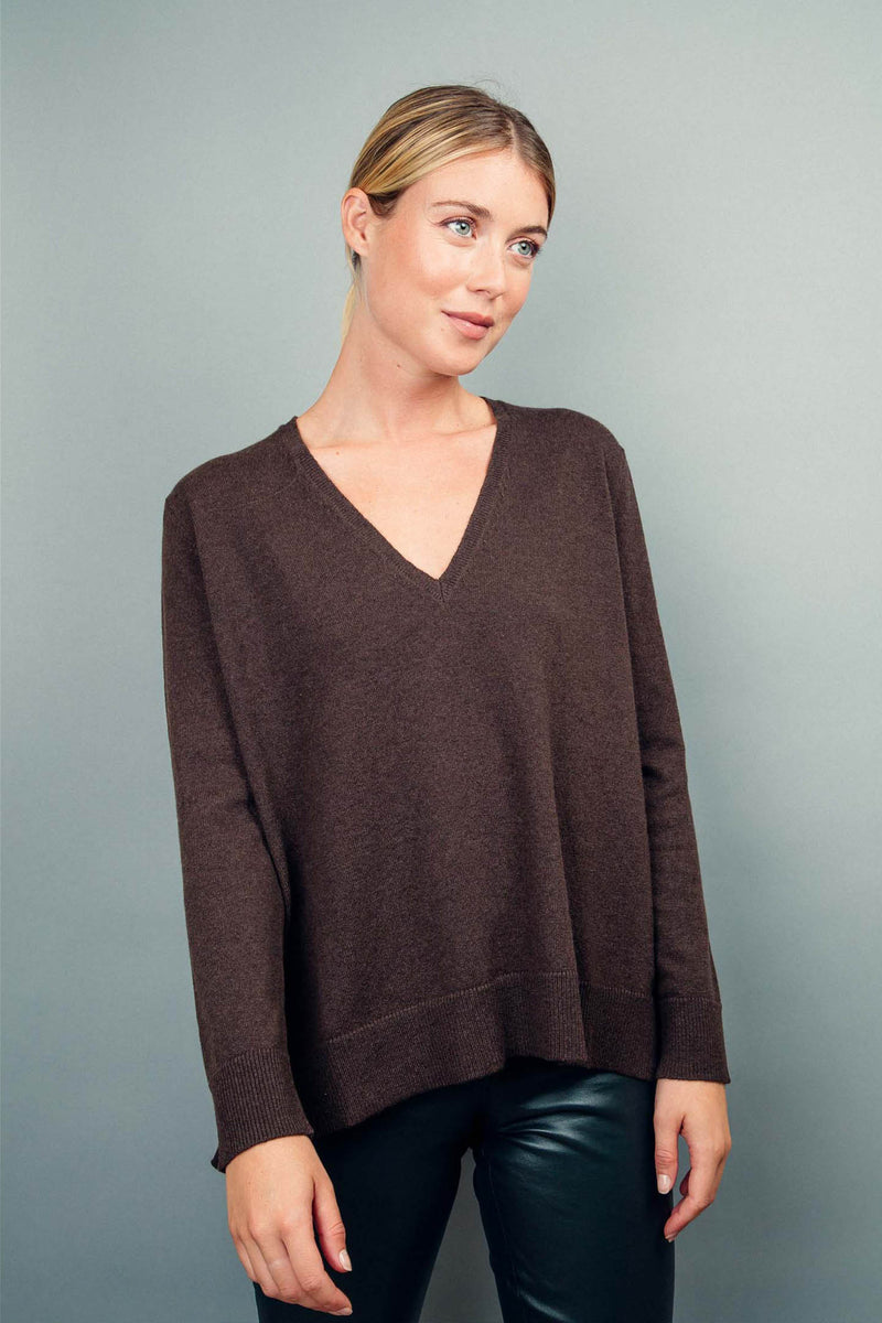 Pull manches longues coloris choco 100% cachemire, col V profond, fendu sur les côtés avec asymétrie: 10 cm dans le dos et 7 cm devant. Finitions bords côtes. 