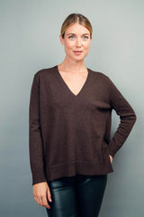 Pull manches longues coloris choco 100% cachemire, col V profond, fendu sur les côtés avec asymétrie: 10 cm dans le dos et 7 cm devant. Finitions bords côtes. 