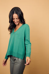 Pull manches longues coloris lierre (vert tendre) 100% cachemire, col V profond, fendu sur les côtés avec asymétrie: 10 cm dans le dos et 7 cm devant. Finitions bords côtes. 