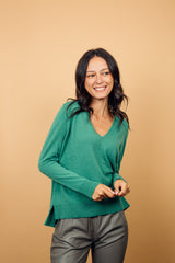 Pull manches longues coloris lierre (vert tendre) 100% cachemire, col V profond, fendu sur les côtés avec asymétrie: 10 cm dans le dos et 7 cm devant. Finitions bords côtes. 