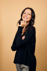 Pull manches longues coloris noir 100% cachemire, col V profond, fendu sur les côtés avec asymétrie: 10 cm dans le dos et 7 cm devant. Finitions bords côtes. 