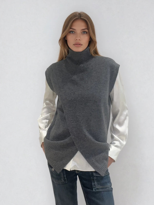 Pull sans manches anthracite  avec un col montant et une ouverture en diagonale sur le devant formant un croisé. A porter avec un chemisier en dessous. Coupe droite et longue.  42% cachemire, 8% soie, 50% mérinos. Vue face.