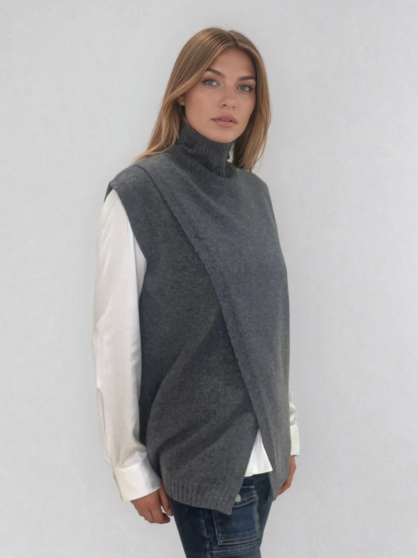 Pull sans manches anthracite  avec un col montant et une ouverture en diagonale sur le devant formant un croisé. A porter avec un chemisier en dessous. Coupe droite et longue.  42% cachemire, 8% soie, 50% mérinos. Vue profil.