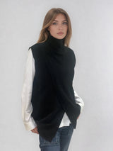Pull sans manches noir avec un col montant et une ouverture en diagonale sur le devant formant un croisé. A porter avec un chemisier en dessous. Coupe droite et longue.  42% cachemire, 8% soie, 50% mérinos. Vue profil.
