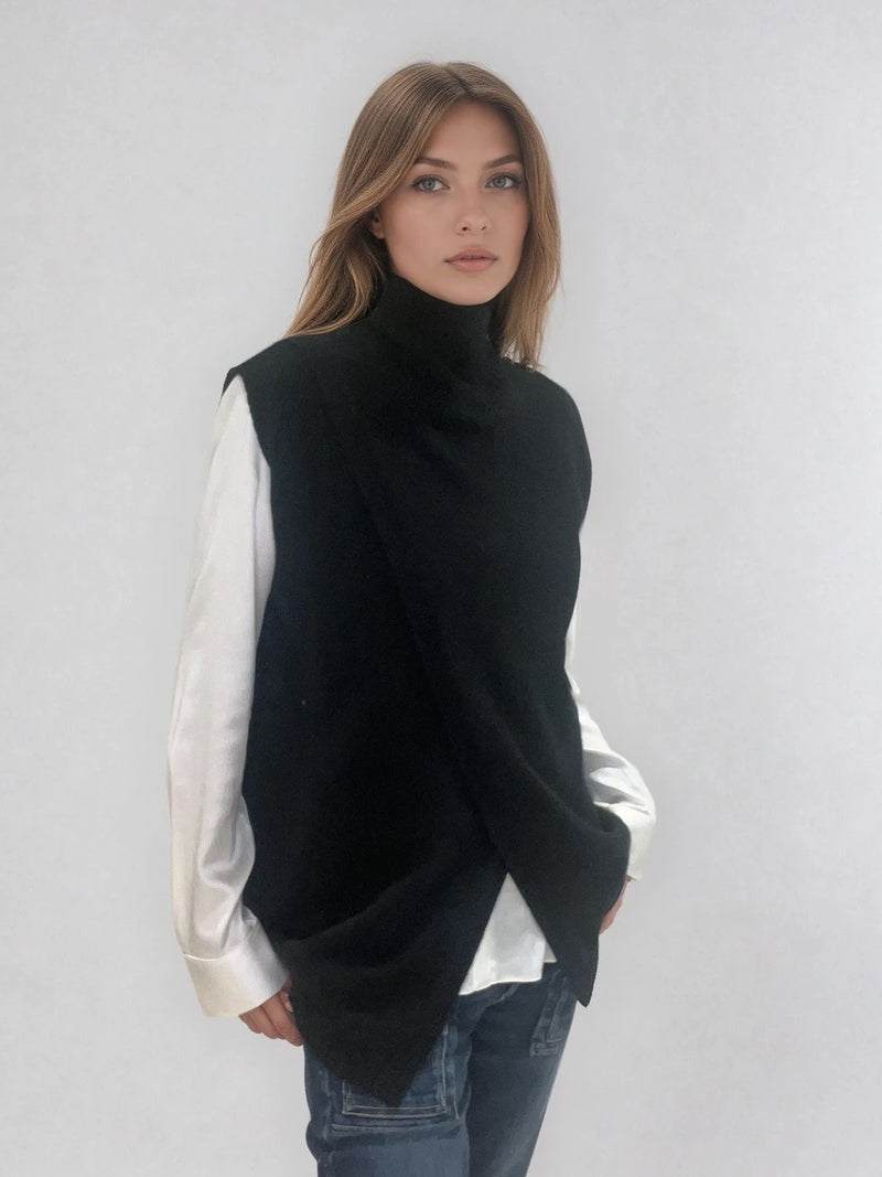 Pull sans manches noir avec un col montant et une ouverture en diagonale sur le devant formant un croisé. A porter avec un chemisier en dessous. Coupe droite et longue.  42% cachemire, 8% soie, 50% mérinos. Vue profil.