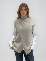 Pull sans manches taupe avec un col montant et une ouverture en diagonale sur le devant formant un croisé. A porter avec un chemisier en dessous. Coupe droite et longue.  42% cachemire, 8% soie, 50% mérinos. Vue face.