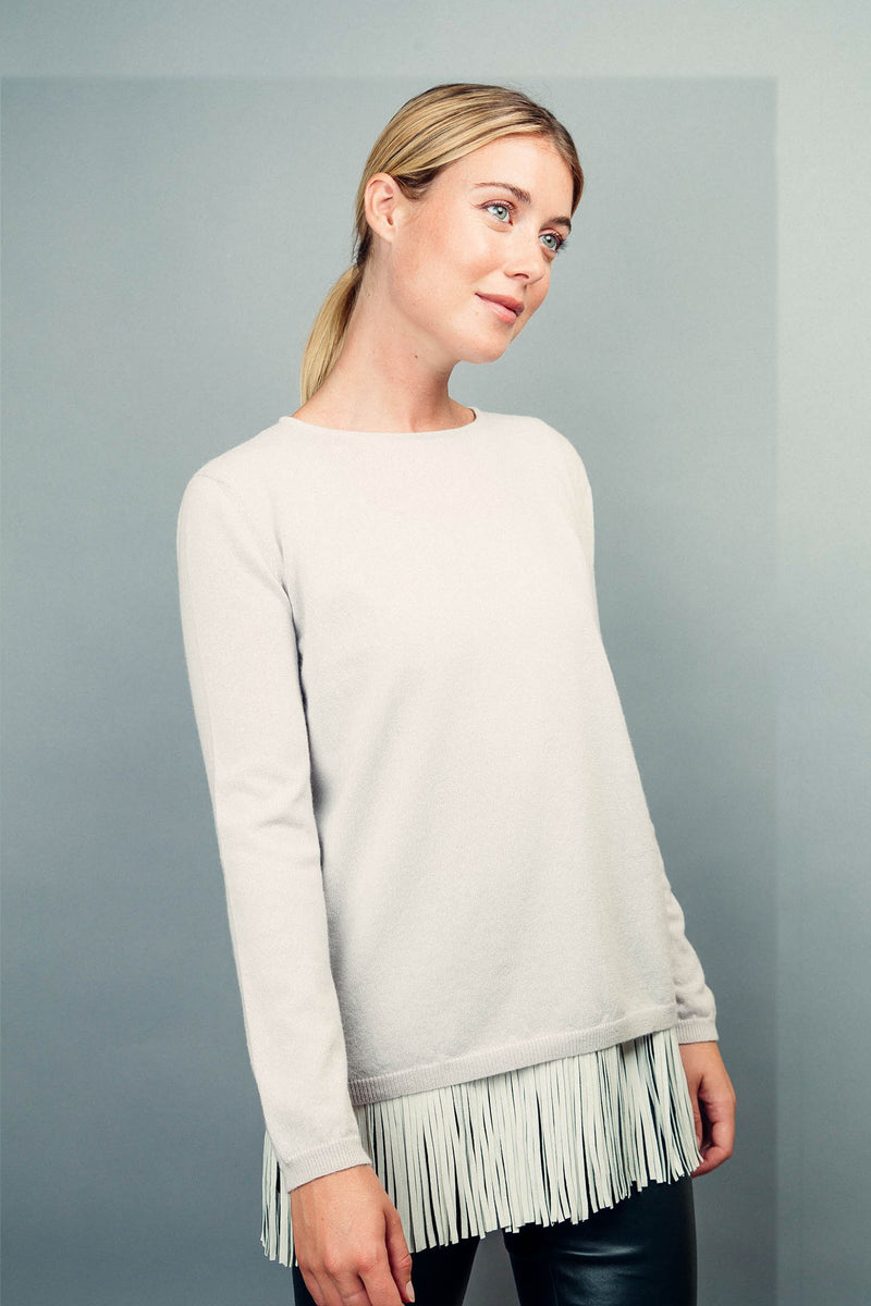 Pull MARIE blanc 100% cachemire avec un col rond ourlé, manches longues. Coupe droite.
Petite finition bords côtes sur les manches et le bas. Est présenté au-dessus d' un débardeur en soie et franges en cuir qui ne laisse voir que les franges .