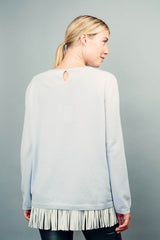 Pull MARIE gris très clair 100% cachemire avec un col rond ourlé, manches longues. Coupe droite.
Petite finition bords côtes sur les manches et le bas. Est présenté au-dessus d' un débardeur en soie et franges en cuir qui ne laisse voir que les franges .