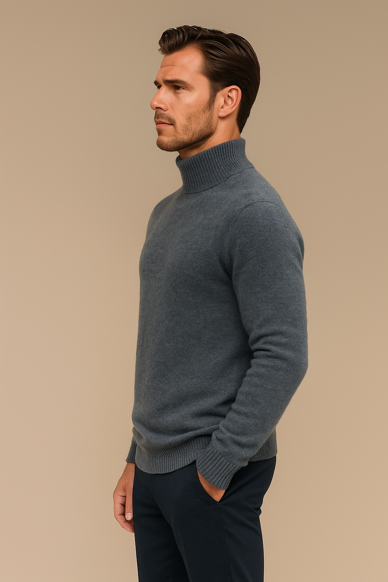 Pull col roulé pour homme gris en 71%cachemire, 19%soie et 10% polyester. Le pull a un col haut très souple, la matière est extrêmement douce et chaude. La forme est droite et les manches longues raglan. Finitions côtes. Vue profil.