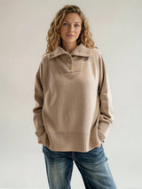 Pull manches longues coloris camel oversize avec un col montant façon camionneur 5 boutons dorés. Le col est souligné par un empiècement plastron et se rabat sur les épaules. Larges côtes. Composition: 42% cachemire, 8% soie, 50% mérinos.