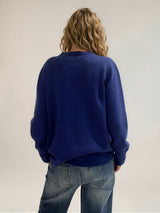 Pull manches longues coloris bleu avec un col rond souple. Le pull a une forme droite. Composition: 42% cachemire, 8% soie, 50% mérinos.